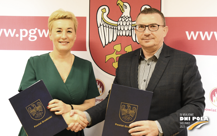 Wicedyrektor Alicja Stachowiak oraz starosta Mariusz Zgaiński stoją z podpisanymi listami intencyjnymi i ściskają sobie dłonie